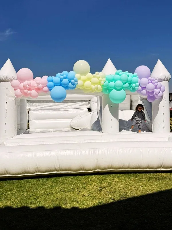 Castillo inflable blanco con globos arcoíris