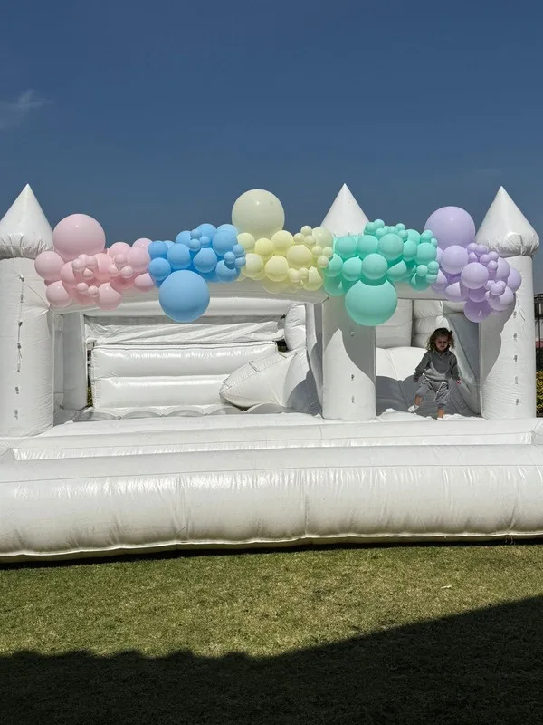 Castillo inflable blanco con globos pastel